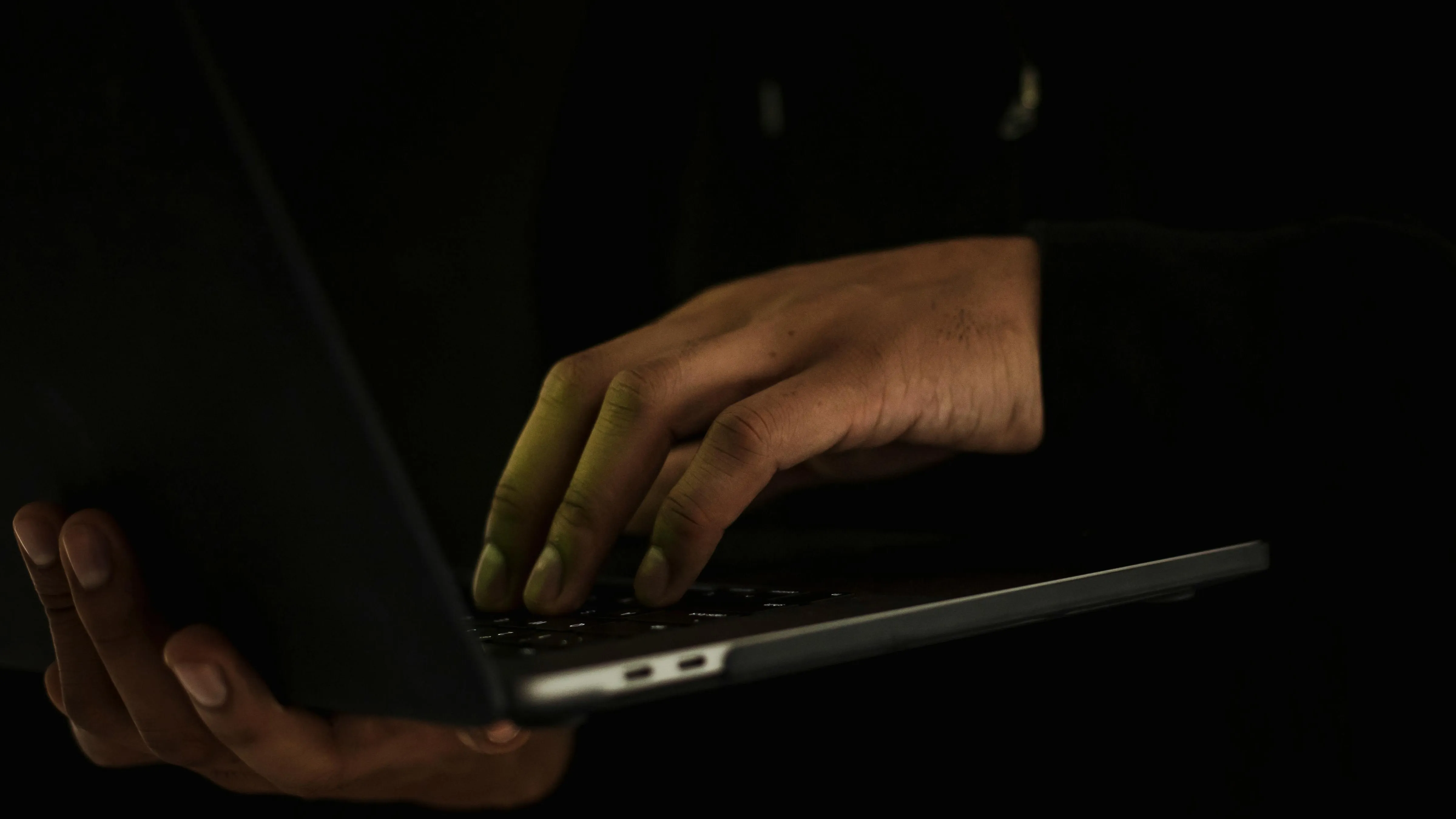 Мужчина держит ноутбук в темноте фото на taspanews.kz от 24 апреля 2024 15:55