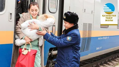 Проводник помогает женщине с ребенком выйти из вагона поезда