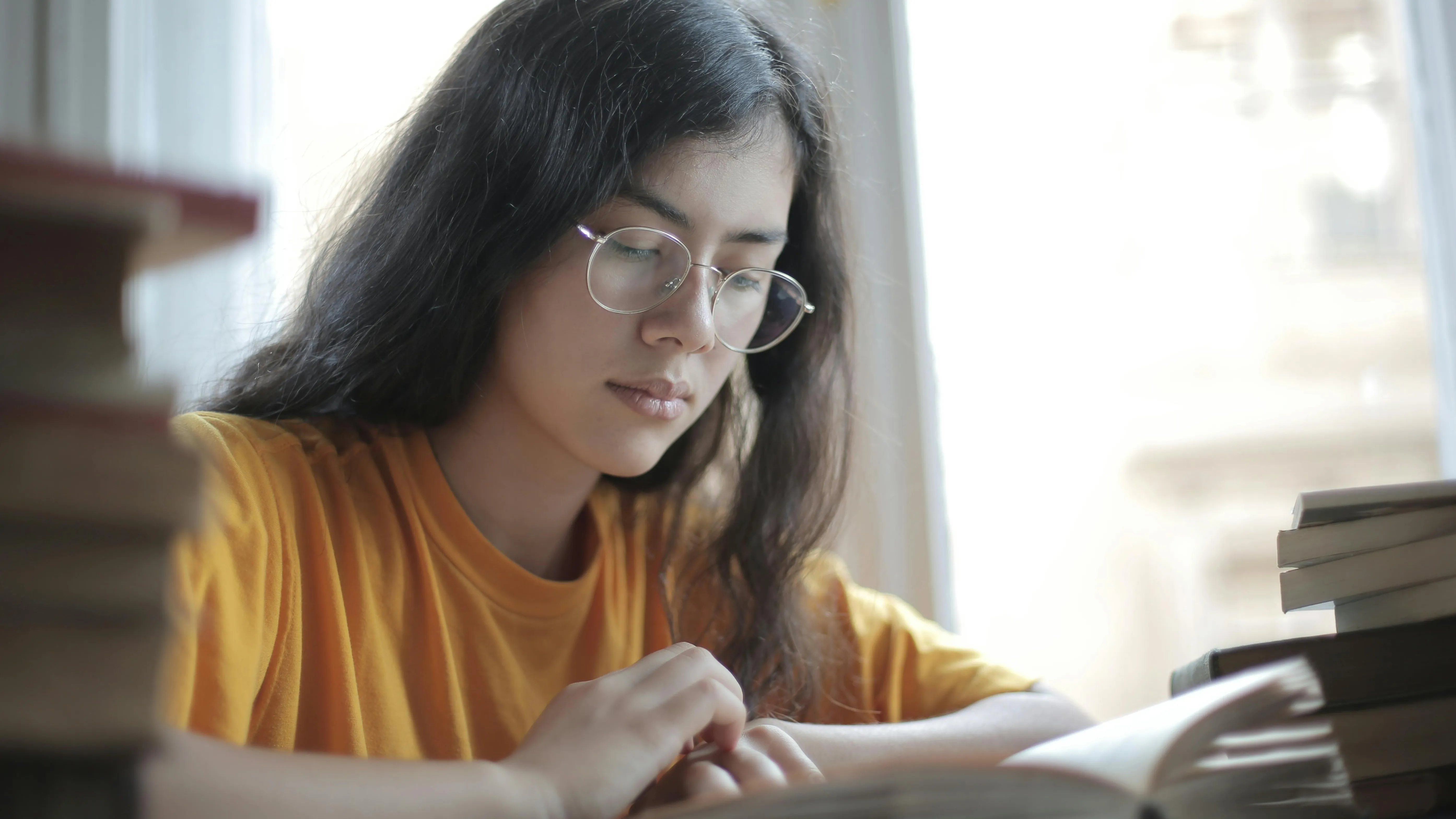 Девушка в очках сидит над учебниками фото на taspanews.kz от 27 мая 2024 11:54