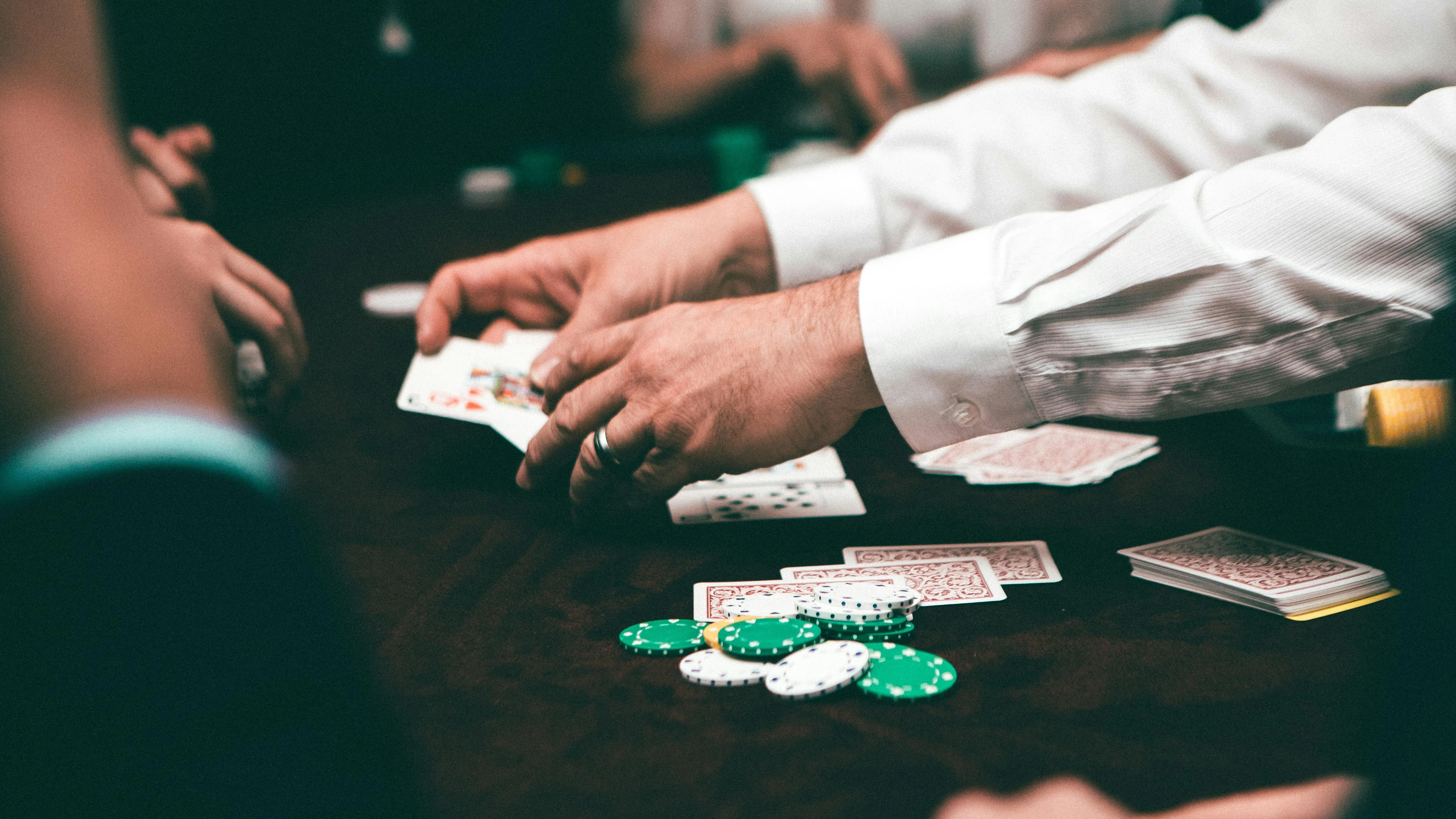 Руки крупье, раздающего карты за игральным столом в казино фото на taspanews.kz от 27 мая 2024 14:11