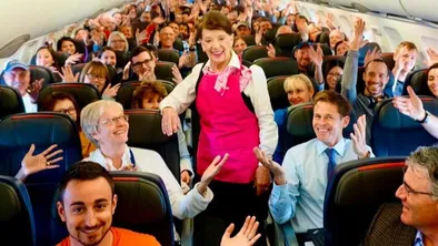 Стюардесса в салоне самолета с пассажирами