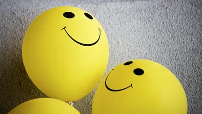 Желтые водушные шарики с нарисованными улыбками