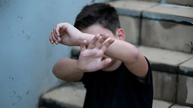 Ребенок закрывает лицо руками