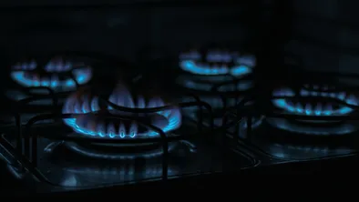 Четыре конфорки горят на газовой плите в темноте