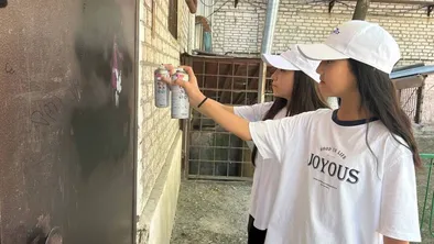 Девушки закрашивают граффити