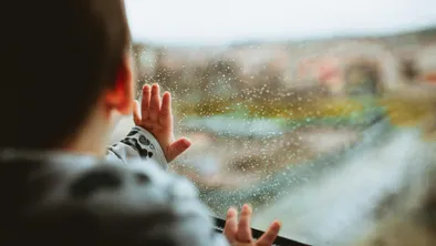 Ребенок у окна, идет дождь