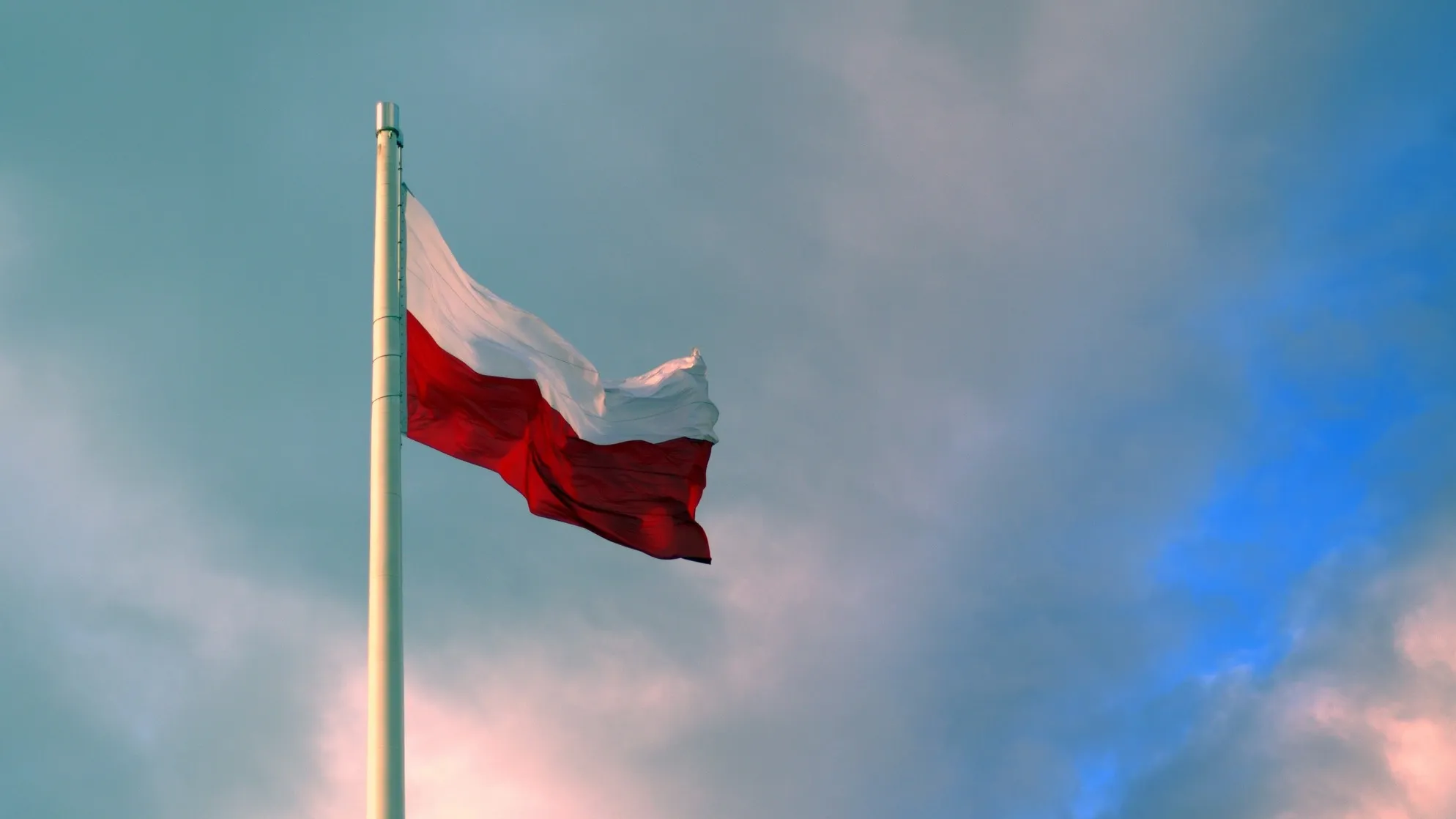Флаг Польши на флагштоке на фоне неба с облаками фото на taspanews.kz от 27 июня 2024 08:41