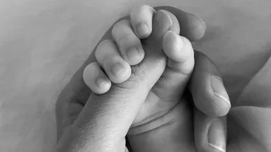 Рука младенца в руке женщины